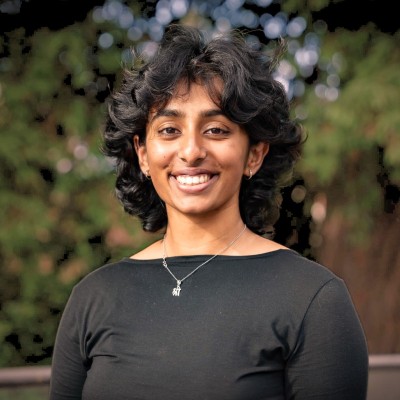 Sanjana Gurram stands in front of a forested backdrop.